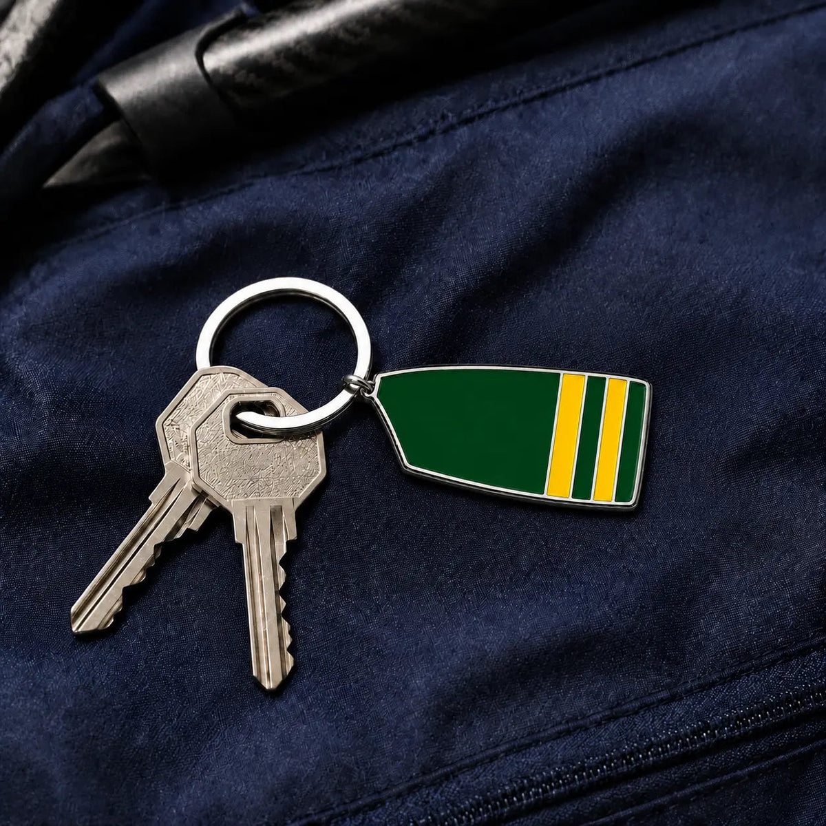 Custom rowing oar keyring attached to keys on a navy rowing bag